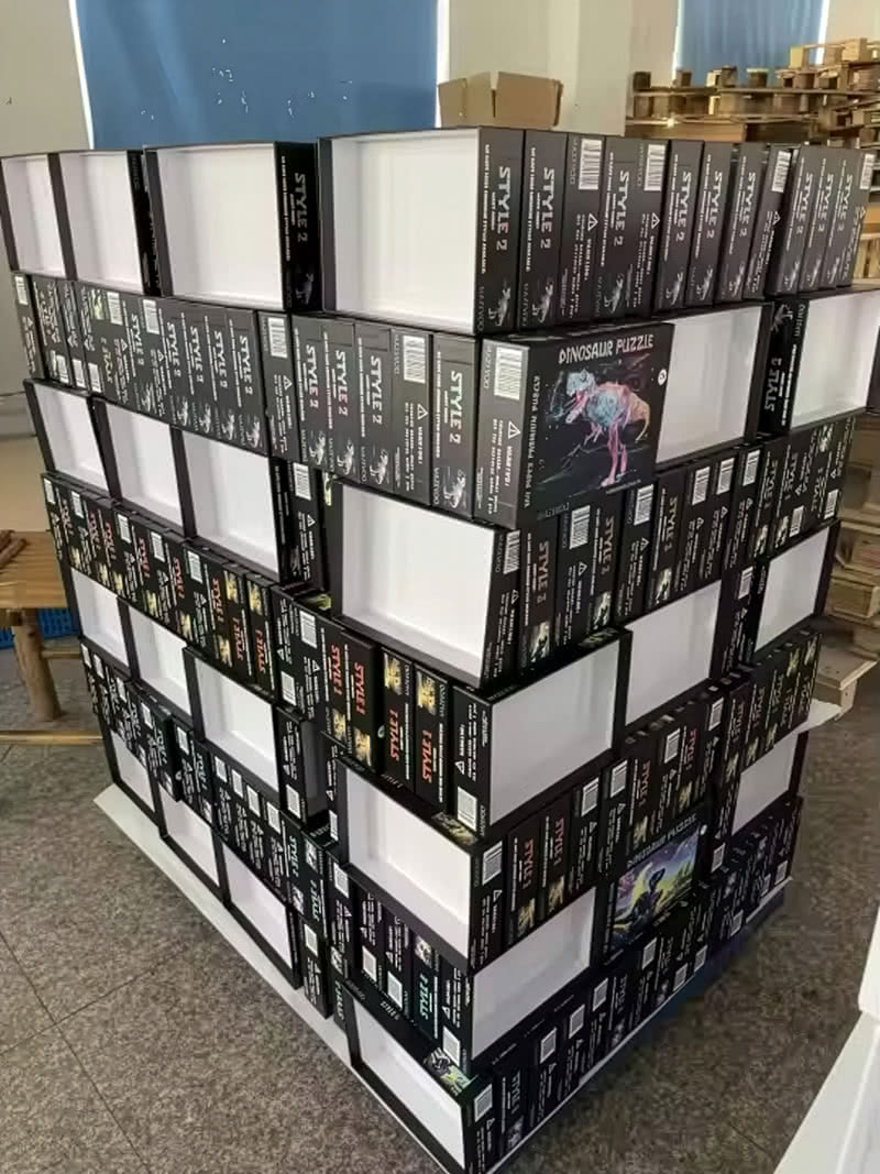 Stacks of boxed puzzles prepared for local donation through the Stay Playful Project